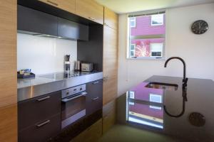a kitchen with a stove and a sink and a window at Marina Apartments - Element Escapes in Queenstown