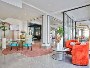 a lobby with orange chairs and a table at Hotel Plaza Biarritz Plage - Handwritten Collection in Biarritz