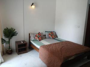 a bedroom with a bed and a potted plant at ATS Grand Casa 02 in Greater Noida