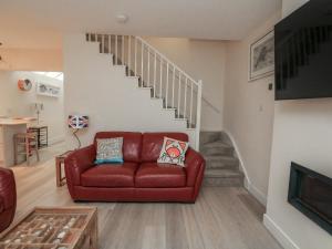 a living room with a red couch and stairs at Full Deck in Dartmouth