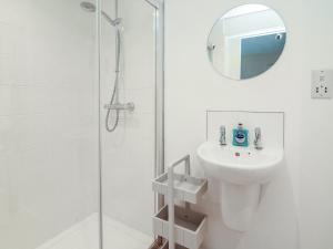 a white bathroom with a sink and a shower at Full Deck in Dartmouth +16 photos