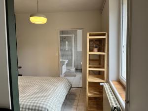 a small bedroom with a bed and a bathroom at La Estancia in Montsauche