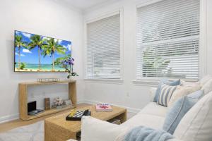 a living room with a white couch and a fireplace at Boutique condo w oceanfront & concierge in Palm Beach