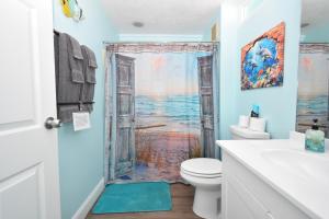 a bathroom with a toilet and a shower with a window at Cedar Key Islands Dolphins Cay Condo 230 in Cedar Key +13 photos