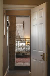 a door leading to a bedroom with a bed in a room at King William in Bath