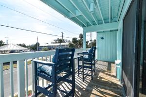 two blue chairs sitting on the porch of a house at Cedar Key Islands Dolphins Cay Condo 230 in Cedar Key