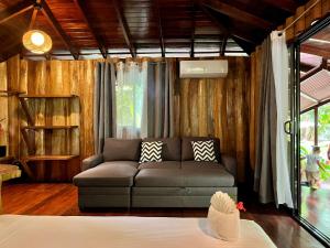 a living room with a couch and a window at Hotel La Costa de Papito in Puerto Viejo