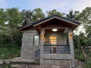 a small wooden house with a front door at Bungalow small peaceful house in Daanbantayan