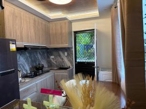a kitchen with wooden cabinets and a counter top at Bungalow small peaceful house in Daanbantayan