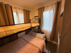 a room with two bunk beds and a window at Bungalow small peaceful house in Daanbantayan
