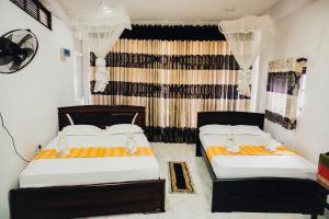 a bedroom with two beds and a window at SECRET MIRAGE Ella in Ella