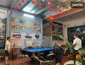 a group of people standing around a pool table at Mountain View Hostel in Bố Trạch