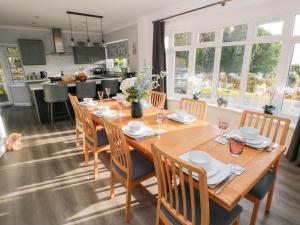 a dining room with a wooden table and chairs at Westwinds in Tenby