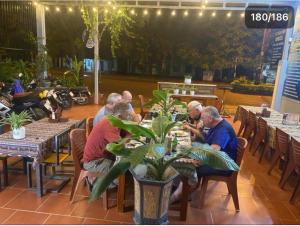 a group of men sitting at tables in a restaurant at Mountain View Hostel in Bố Trạch