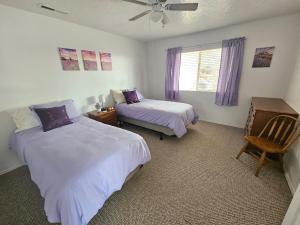 a bedroom with two beds and a chair and a window at Mountain View near Zion in Hurricane