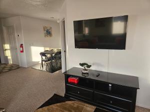a living room with a black dresser with a television on a wall at Mountain View near Zion in Hurricane