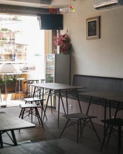 a group of tables and chairs in a restaurant at DOM Hotel Jogja in Yogyakarta