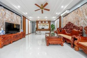 a living room with wooden furniture and a flat screen tv at Hoa Lu Majestic Hotel - Phố cổ Hoa Lư, Ninh Bình in Kỳ Vĩ