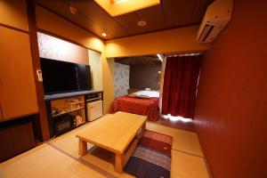 a small room with a bed and a television at Hotel Mju-Adult Only in Tokyo