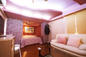 a living room with a couch and a bed at Hotel Mju-Adult Only in Tokyo