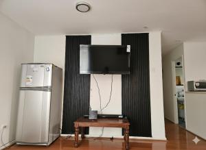 a room with a refrigerator and a table with a television at Algarrobo, house in a condominium in Algarrobo