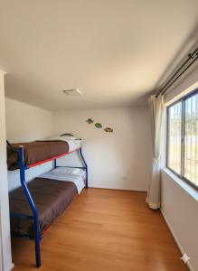 a room with two bunk beds and a window at Algarrobo, house in a condominium in Algarrobo +2 photos