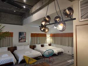 a room with two beds and two chairs at HAMBY101 in Chatan