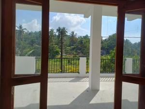 an open door to a balcony with palm trees at villa calm haven in Unawatuna