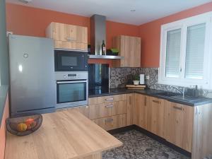 a kitchen with wooden cabinets and a wooden table at Le cosy de Cholet près du PUY DUFOU in Cholet
