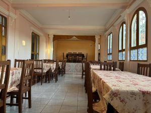 a dining room with tables and chairs and windows at Palacio Asteria in Torotoro