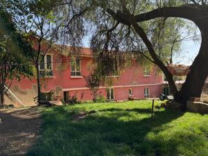 a red building with a tree in front of it at Palacio Asteria in Torotoro +20 photos