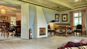 a living room with a fireplace and a table at Historic Farmhouse From 1848 in Hårby