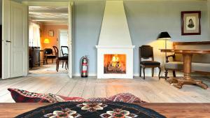 a living room with a fireplace and a piano at Historic Farmhouse From 1848 in Hårby