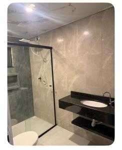 a bathroom with a shower and a toilet and a sink at Apartamento Casa pontarolo in Guarapuava