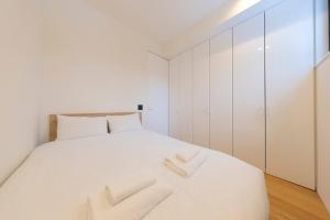 a bedroom with a white bed with white cabinets at Kouzan Woods in Kaributo +17 photos