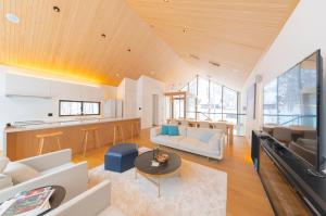 a living room with white furniture and a kitchen at Kouzan Woods in Kaributo