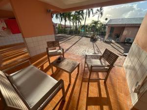 a patio with three chairs and a couch and a table at Kay Nono in Rivière-Salée