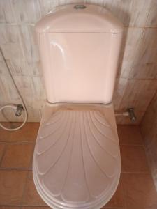 a white toilet with the lid down in a bathroom at The Garden Villa in Matara