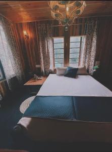 a large bed in a room with a window at Lee's Grandma's Will Cottage in Kalimpong +16 photos