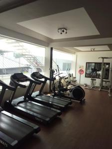 a gym with several cardio machines in a room at Caesars fitness in Jāmb