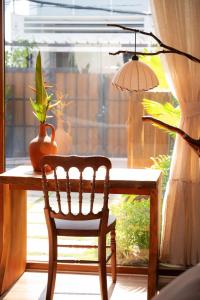 a table with a chair and a lamp and a plant at MAISON à SADEC in Ấp Tân An (2)