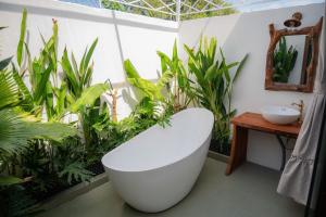 a bathroom with a bath tub and plants at MAISON à SADEC in Ấp Tân An (2) +21 photos