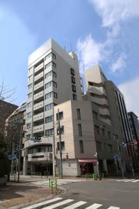 twee hoge gebouwen in een stad met een straatkruising bij City Pension Zem in Tokyo