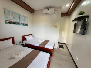 a hotel room with two beds and a tv at Elejea's Inn in Sinai