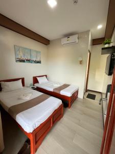 a hotel room with two beds and a television at Elejea's Inn in Sinai