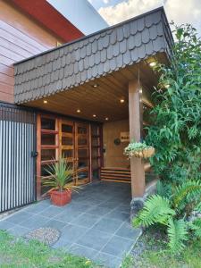 a house with a porch with plants in front of it at Loft Volcan Villarrica in Licán Ray +7 photos