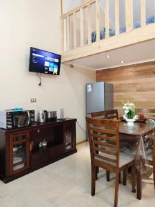a dining room with a table and a refrigerator at Loft Volcan Villarrica in Licán Ray