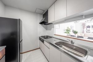 a kitchen with a sink and a stainless steel refrigerator at Hills Niseko C in Niseko