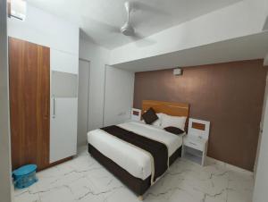 a bedroom with a large bed with a wooden headboard at Utsavam Hotel Apartments in Guruvāyūr +72 photos