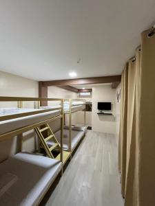 a dorm room with bunk beds and a tv at Elejea's Inn in Sinai +11 photos